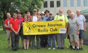 A group of club members holding an Ottawa Amateur Radio Club banner.